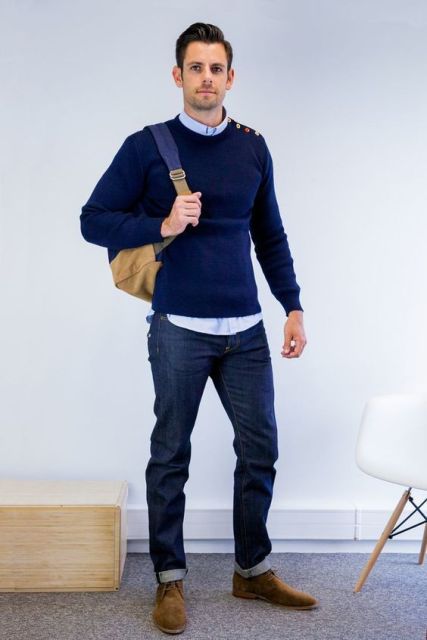 With light blue shirt, navy blue sweater, cuffed jeans and backpack