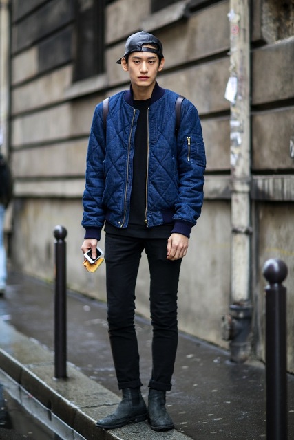 With navy blue puffer jacket, black pants, black boots and backpack