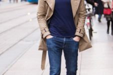 With navy blue t-shirt, jeans, white sneakers and beige trench coat