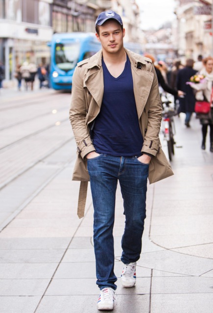 With navy blue t-shirt, jeans, white sneakers and beige trench coat