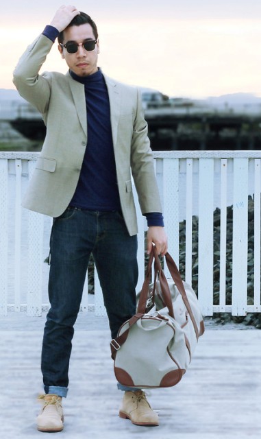 With navy blue turtleneck, beige jacket, jeans and two color bag