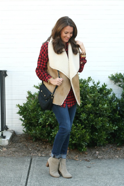 With plaid shirt, cuffed jeans, suede ankle boots and black bag