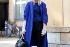 With printed shirt, black trousers, blue shoes, blue coat and black bag
