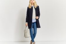With shirt, beige sweater, skinny jeans, suede boots and light gray bag