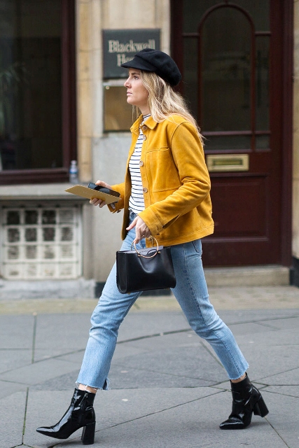 With striped shirt, yellow jacket, crop jeans, black leather boots and ring handle bag