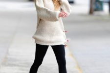 With white oversized sweater, leggings and pumps