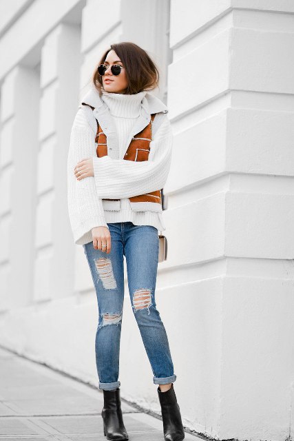 With white turtleneck sweater, distressed cuffed jeans and black leather boots