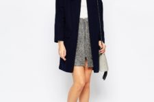 With white turtleneck sweater, tweed skirt, ankle boots and gray bag