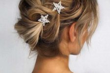 a beautiful and whimsical updo with a loose braid on one side and star rhinestone hairpins is adorable