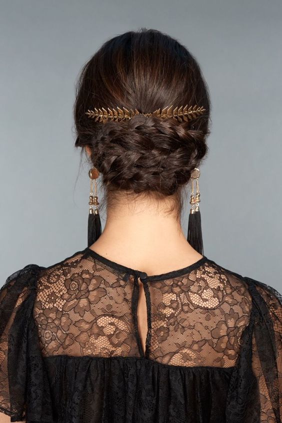 a beautiful braided updo with a sleek top, a gold leaf accent and statement earrings for a chic party look