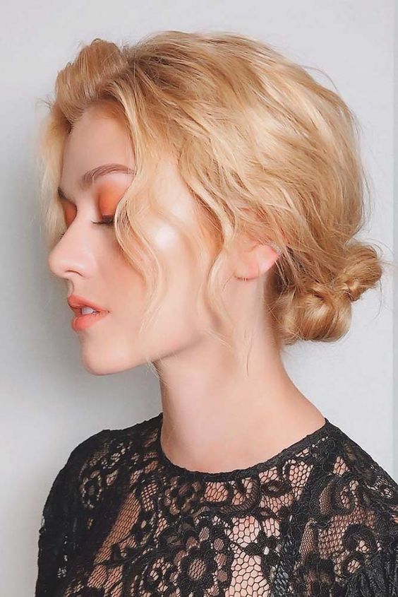 a beautiful wavy braided low bun with a wavy top and some face-frmaing hair is a catchy and cool solution for a Christmas party