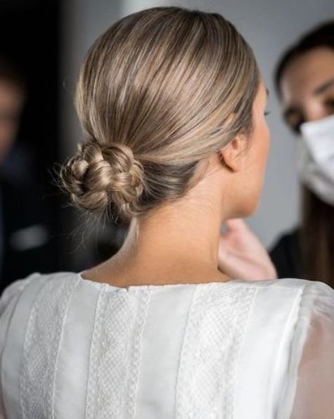 a braided low bun with a sleek top will be a great solution for a holiday party look with a slight boho feel