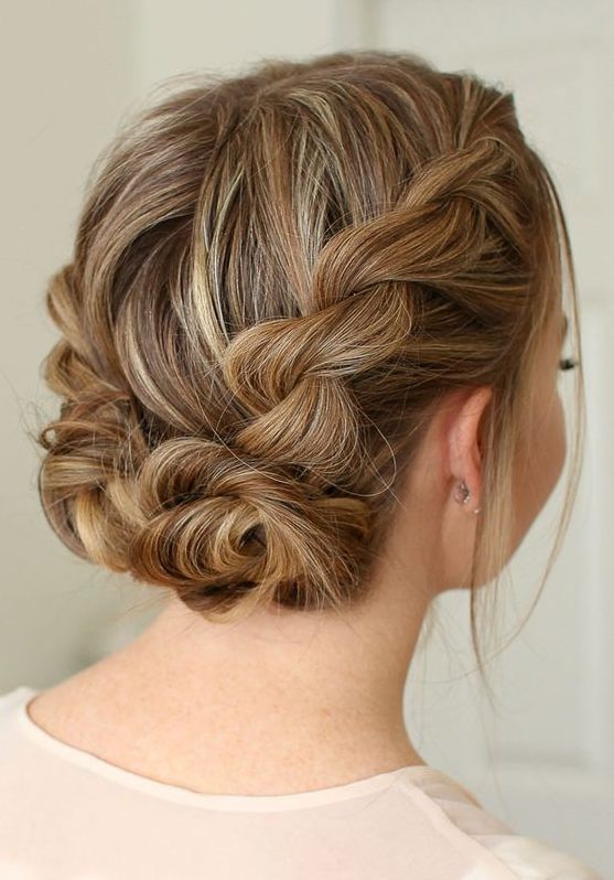 a braided updo with two twisted low buns and volume on top is a chic and stylish idea for a party look with a boho feel