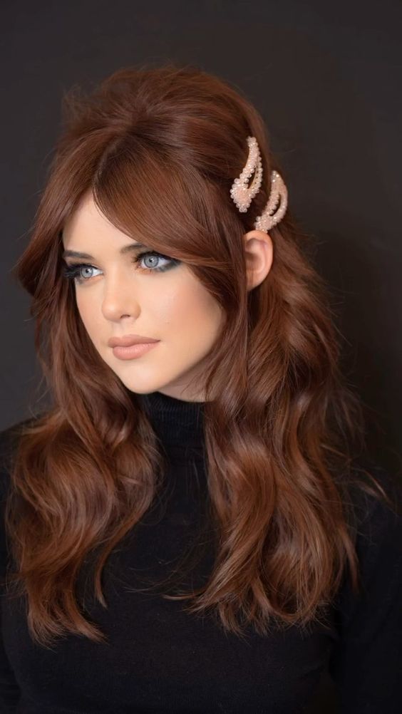 A classy Bardot inspired copper brown hair styled as a half updo, with pink hair pieces and waves down plus face framing hair