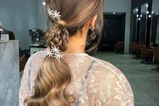 a creative Christmas ponytail with braids and floral haiir pins and waves down is a cool and catchy idea to rock