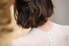 a long bob with wavy hair, styled as a half updo, with a beautiful rhinestona hair barrette is wow