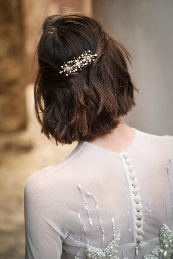 a long bob with wavy hair, styled as a half updo, with a beautiful rhinestona hair barrette is wow