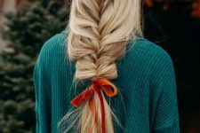 a long loose braid with an orange velvet bow is a cool hairstyle for Christmas, it looks relaxed and lovely