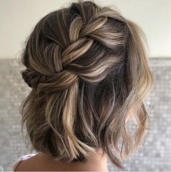 a loose braided halo half updo with waves and some volume is a chic and lovely idea for a boho wedding