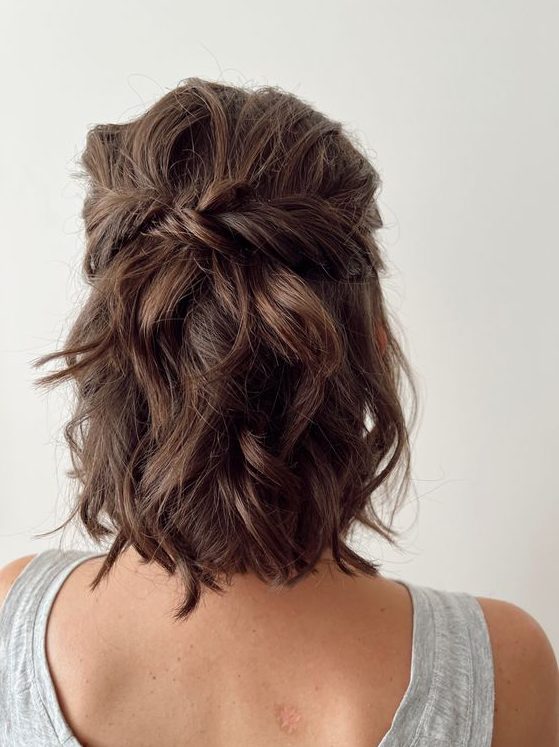 a messy twisted and wavy half updo with waves on top and waves down is a relaxed and cute hairstyle for medium length hair