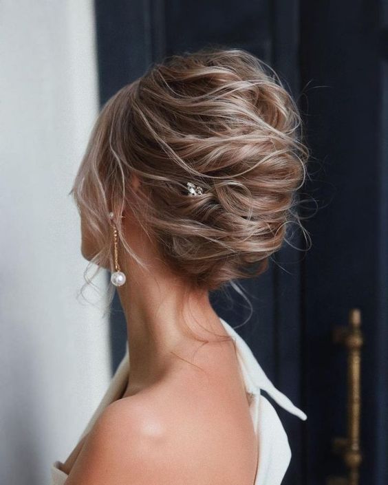 a messy twisted updo with a lot of volume and a rhinestone hairpin looks adorable, it will match many occasions