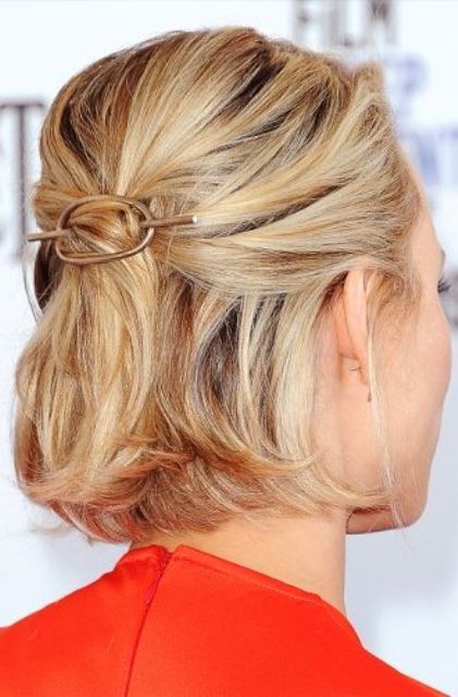 a midi blonde bob styled as a half updo, with a bump on top and a hair piece, with some volume on top