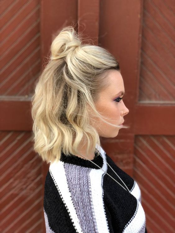 a quick and simple half updo with a messy top knot and waves down plus a lot of volume is chic and catchy