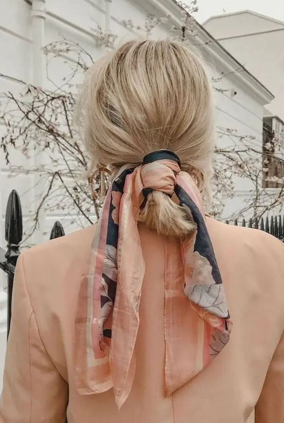 a simple and messy low ponytail with a messy top, a coral scarf as an accessory