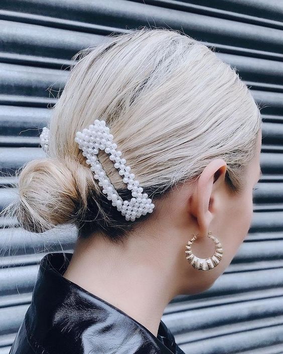a simple low bun with a sleek top and a couple of pearl hair clips is a timeless and fast to make party hairstyle