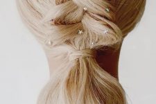 a whimsical Christmas ponytail with a braid styled as a Christmas tree, stars and a star hair pin is a fun idea