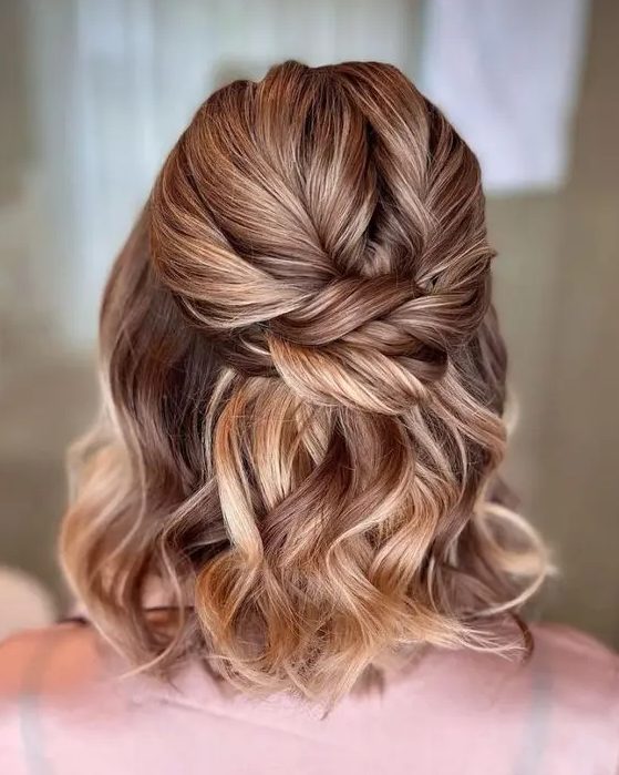 an amazing half updo with a twisted top, a twisted knot and waves down is a cool idea for a modern look