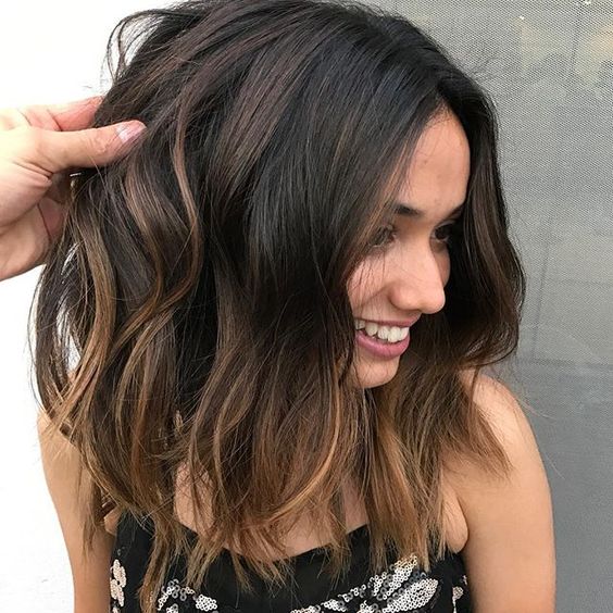dark hair with subtle bronde balayage and messy waves is one of the hottest trends