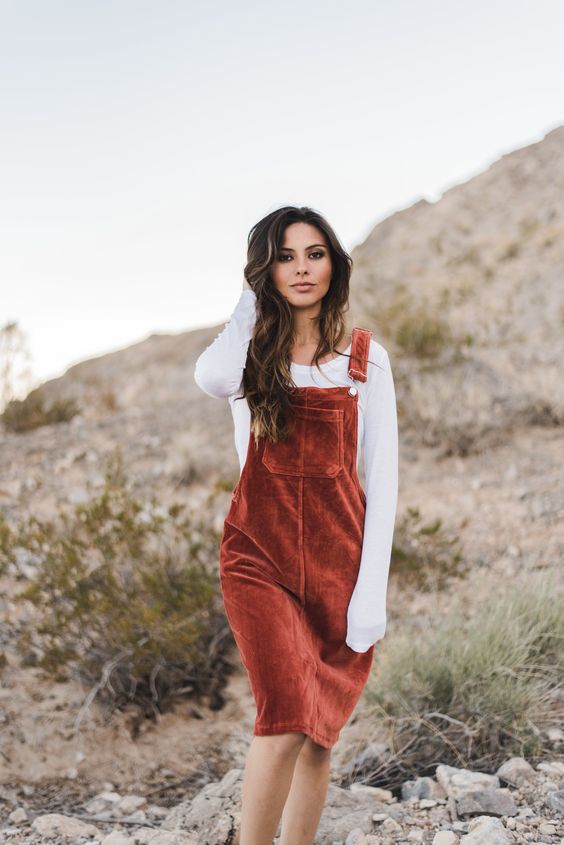 a white long sleeve sweater and a rust velvet overall for a cozy look with a retro feel