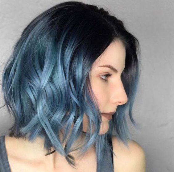 a black roots and metallic blue ombre with waves