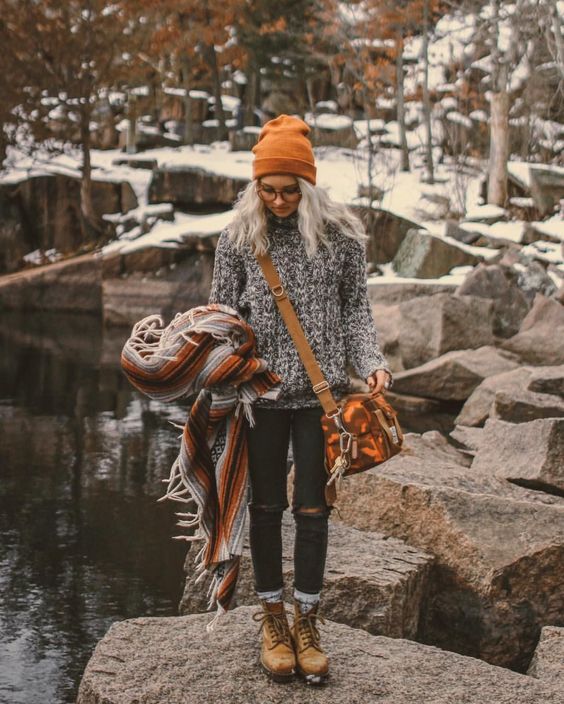 ripped jeans, a chunky knit sweater in black and white, mustard boots, a matching bag and beanie