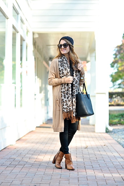 With beanie, beige cardigan, skinny pants, brown ankle boots and black tote