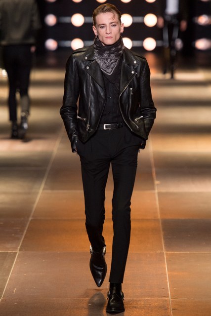 With black shirt, black leather jacket, skinny trousers and leather boots