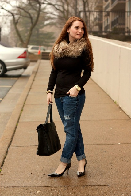 With black shirt, distressed jeans, pumps and bag