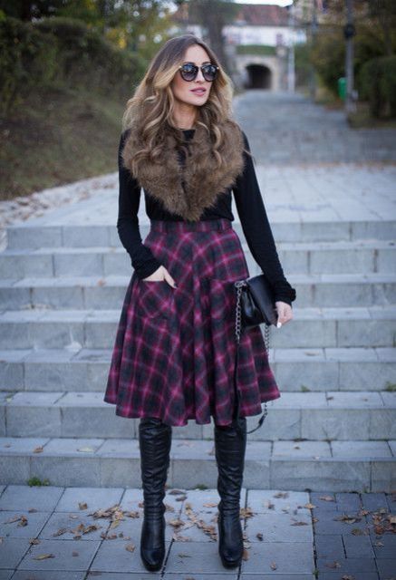 With black shirt, fur collar, high boots and black clutch
