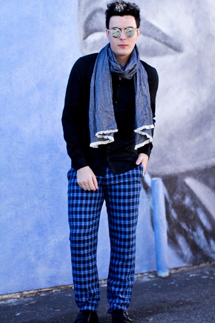 With black sweater, blue scarf and black shoes