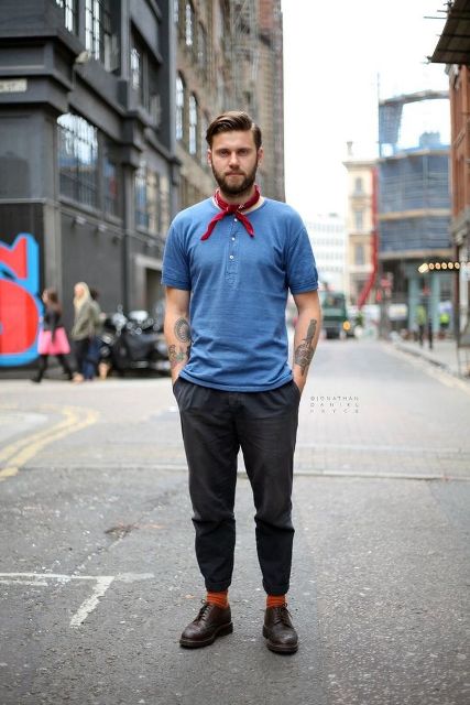 With blue t-shirt, dark gray trousers, orange socks and brown boots