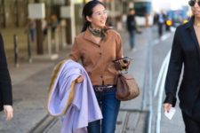 With brown shirt, jeans, lilac coat and brown bag