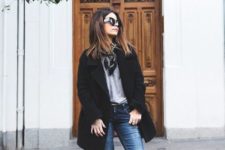 With gray shirt, black coat, distressed jeansa and leopard boots