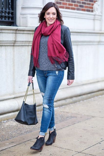With gray sweater, cuffed jeans, ankle boots, leather jacket and bag