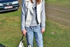 With gray sweatshirt, jeans, black boots and white bag