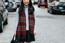 With gray turtleneck sweater, mini skirt, flats and black bag
