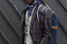 With gray vest, plaid blazer, gray trousers, hat and backpack