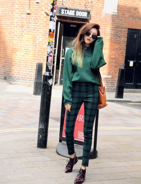 With green loose sweatshirt, brown bag and leather boots