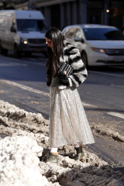 With light gray maxi skirt, black clutch and flat boots
