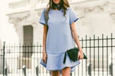 With pastel colored dress, green clutch and lace up boots